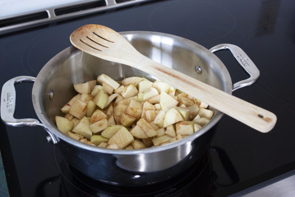peeled and cubed apples sit in a steel pot