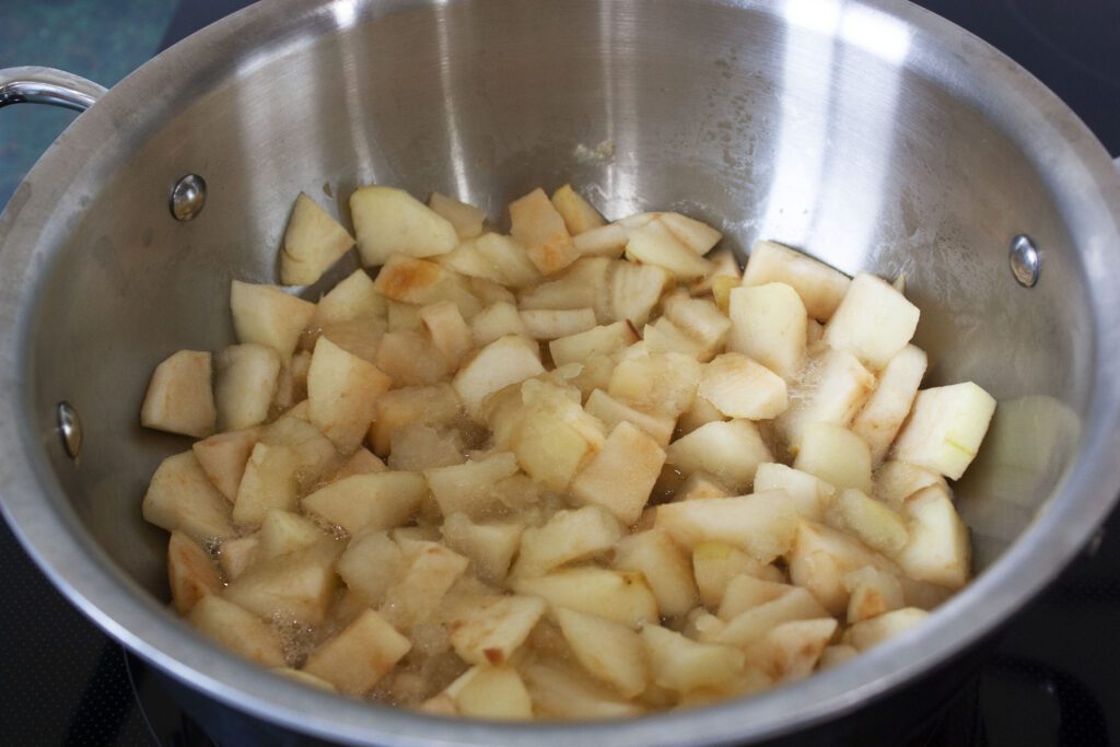 peeled and cubed apples sit in a steel pot