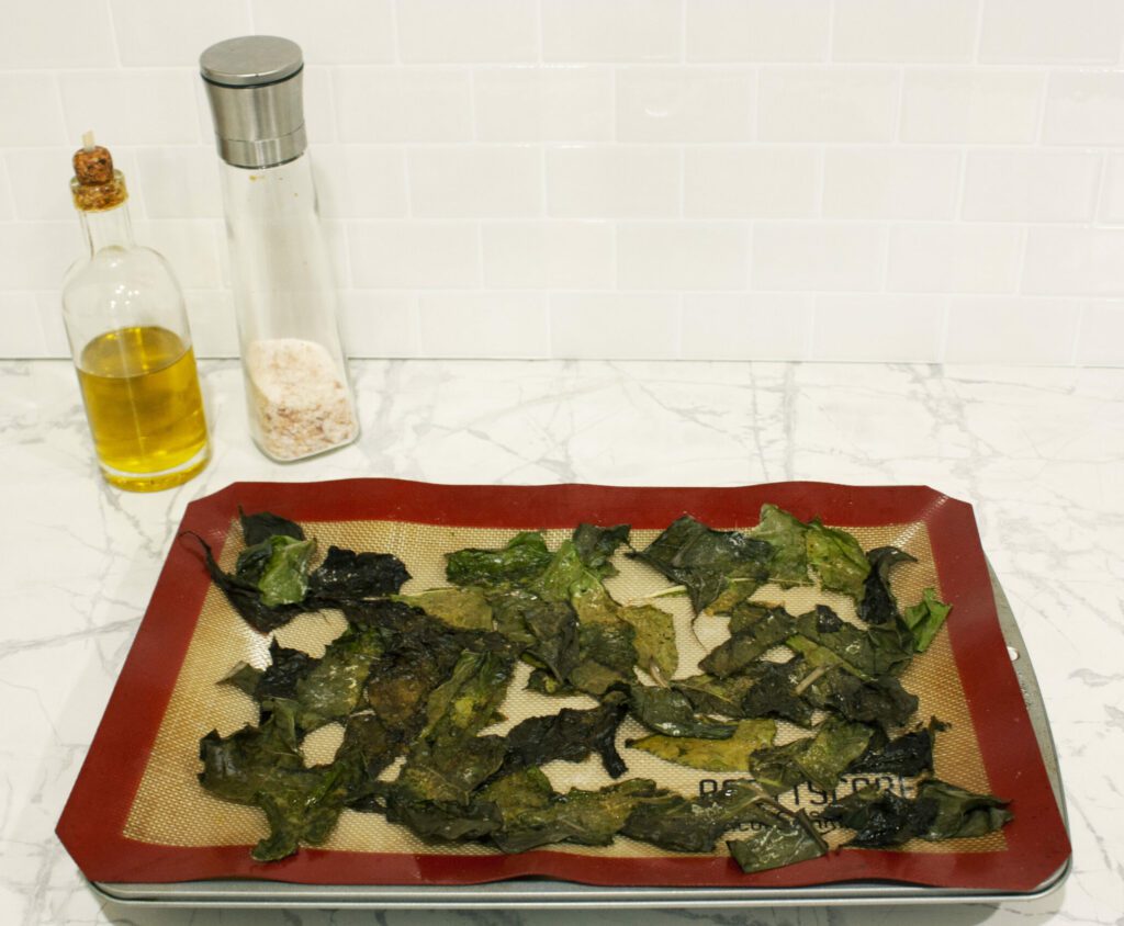 a baking sheet covered in cooked swiss chard chips