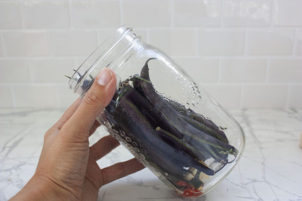 a jar is tilted to its side filled with purple beans