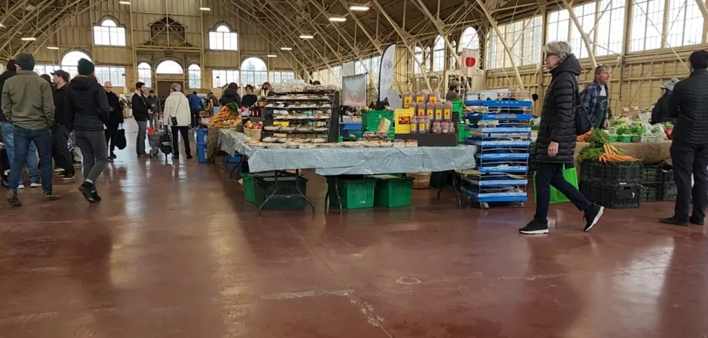 a local farmers market filled with goods like fresh vegetables and apple cider