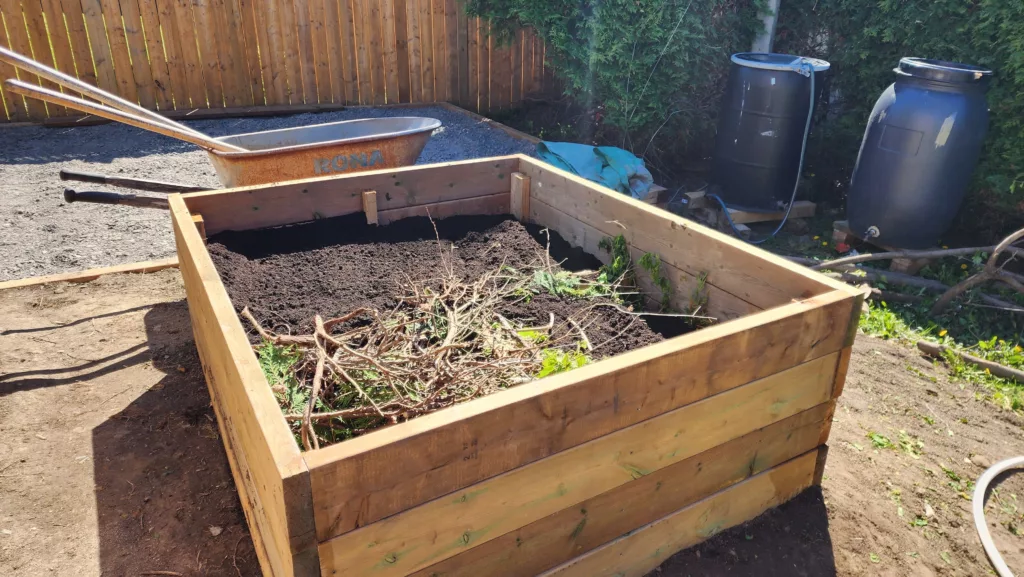 filling up a raised garden bed with soil