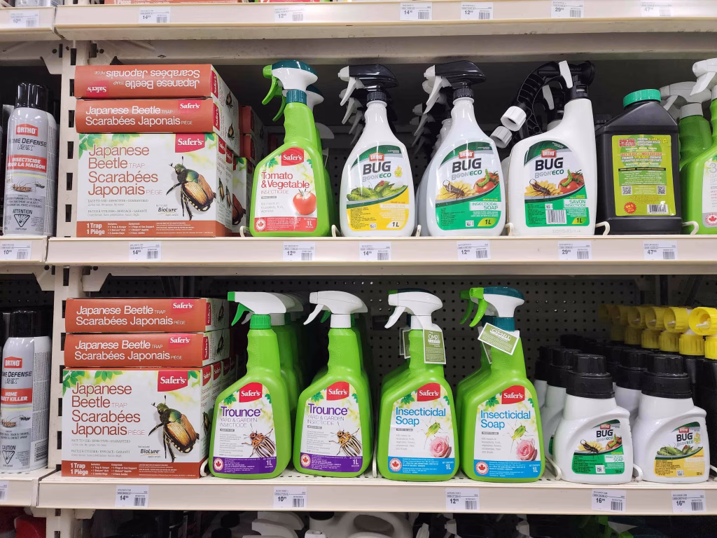 a shelf full of pesticides, herbicides and insecticides plus Japanese beetle traps
